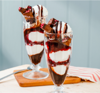 Two Brewers Fayre Vegan Black Forest Sundaes in glasses with cheery and chocolate sauce.